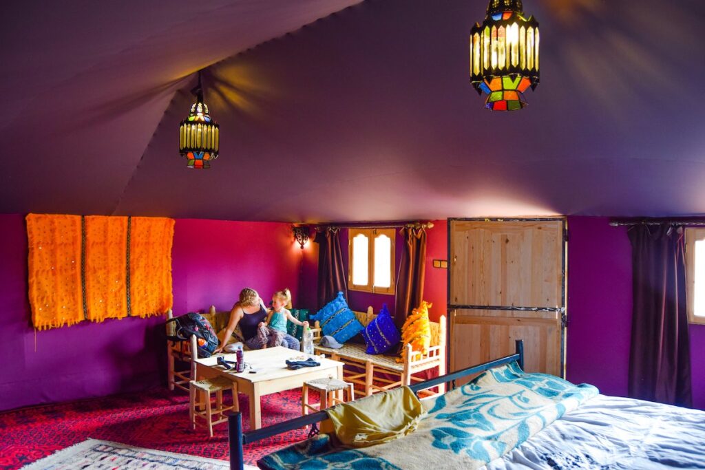 Mother and child sit inside a colourful tent at Ali & Saras Desert Palace Morocco accommodation