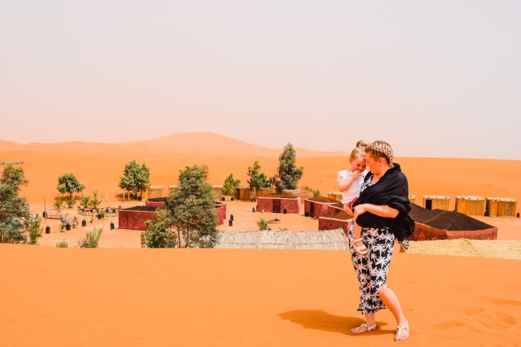 Mother and you daughter stand on a sand dune over looking Ali and Saras Desert Palace Morocco accommodation