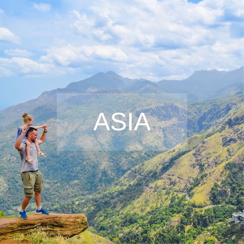 Daughter sits on father shoulders overlooking Little Adams Peak, Sri Lanka 