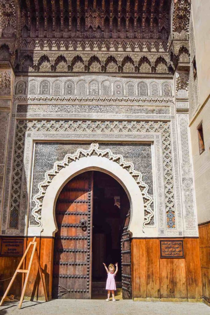 Child stands in doorway in Fes with kids