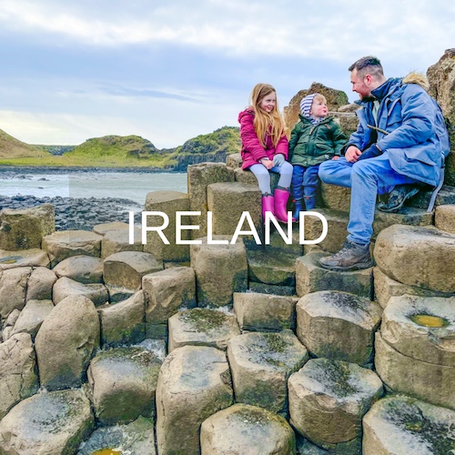 Father and children sit on the Giants Causeway rocks