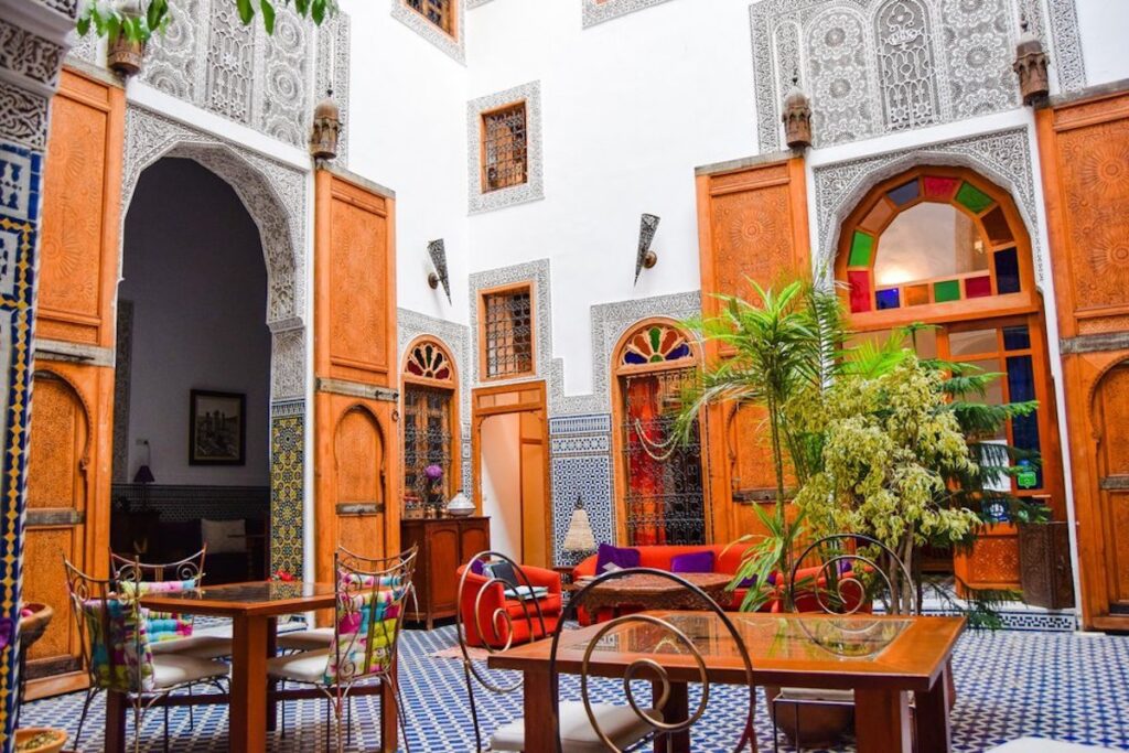 Riad La Clé De Fès courtyard, with moroccan tiles and colourful stained glass