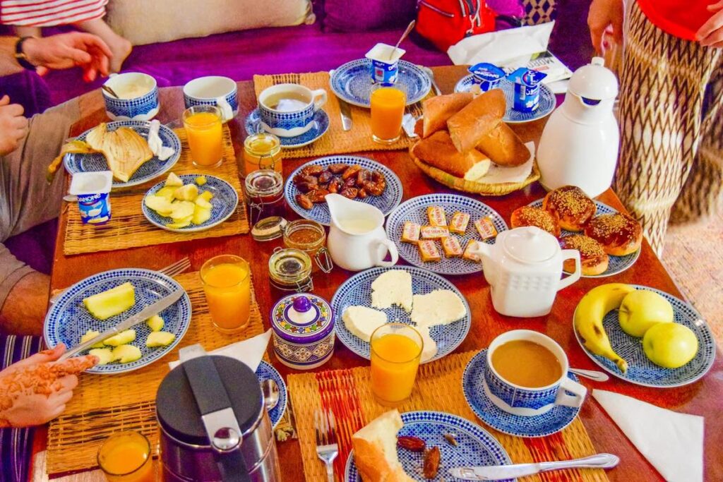 Breakfast table of fresh fruit, coffee, bread and yogurt at Riad La Cle De Fes Morocco accommodation