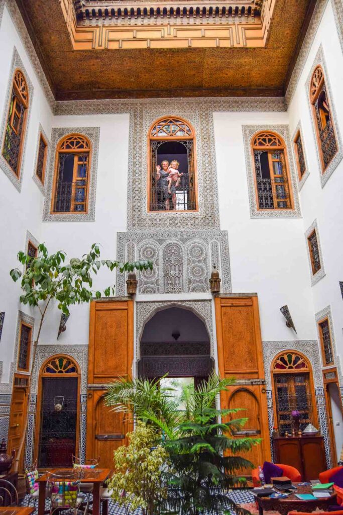 Beautiful interior at Riad La Cle De Fes, with plants, stained glass and Moroccan tiles at Morocco accommodation