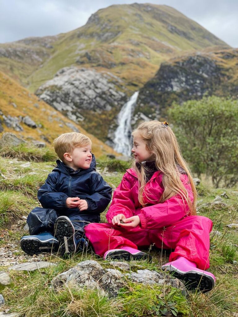 Two children look at each other at Steall Falls 