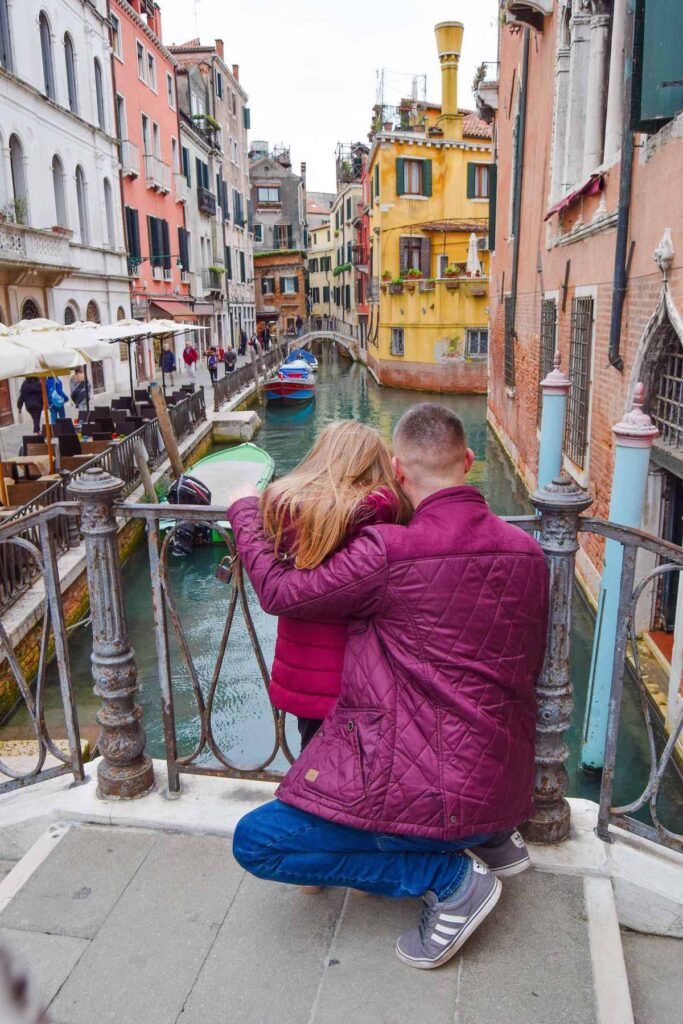 Father and daughter look over a beautiful Venice canal