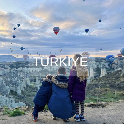 Family in Love Valley Cappadocia watching hot air balloons in the sky