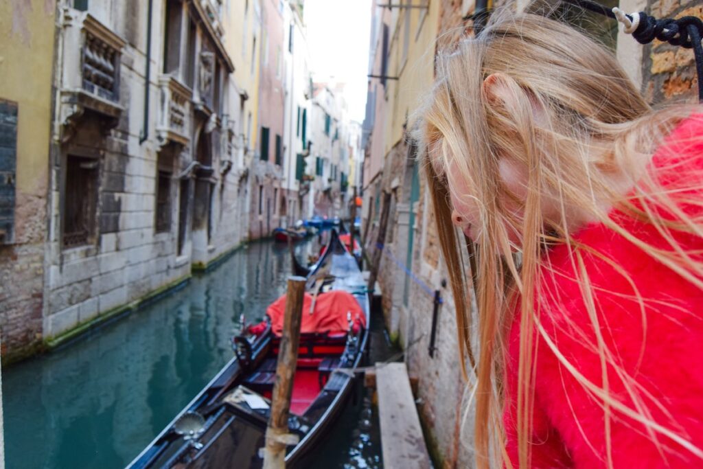 Child sitting next to Venice canal