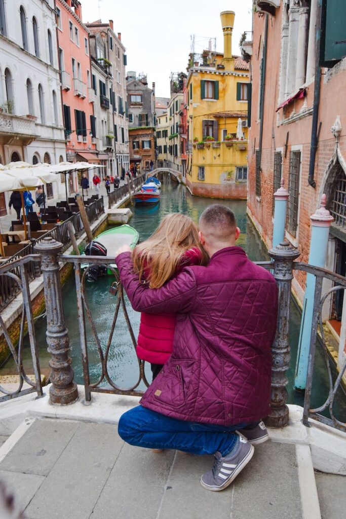 Father and daughter overlooking a quiet canal in Venice, Italy