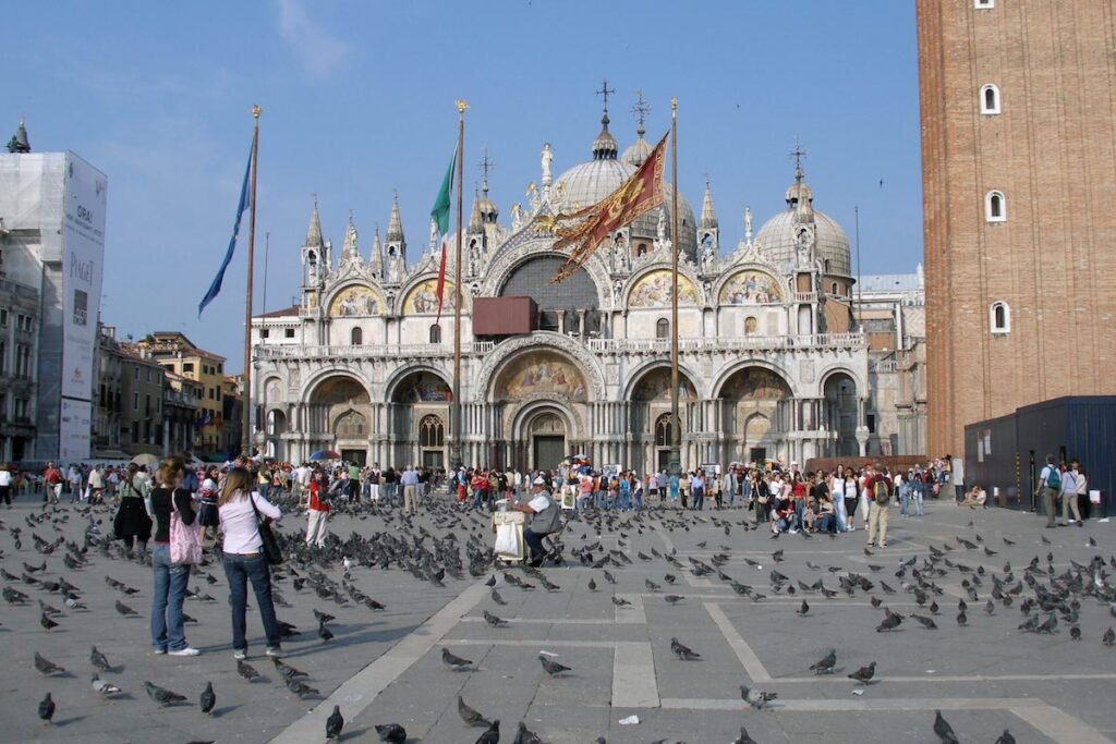 Child feeding pigeons in St Mark’s Square, Venice – Venice with kids