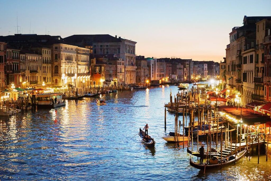 Venice canal at night with reflections of lights on the water