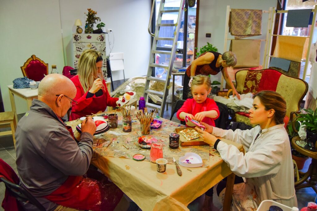 Child decorating a Venetian mask at a mask painting workshop