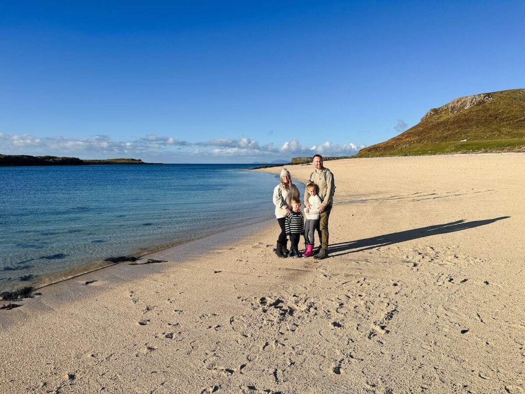 Family with children standing on Coral Beach in the Isle of Skye, Scotland