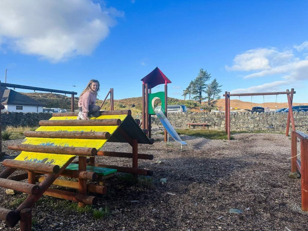 A young girl playing at Sligachan Playground on the Isle of Skye, Scotland, enjoying the outdoor play equipment