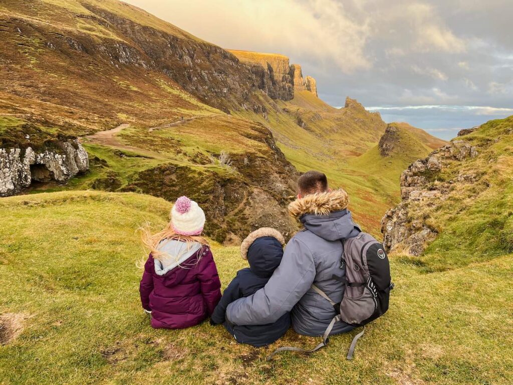 Family sitting on the hillside at the Quiraing on the Isle of Skye, Scotland