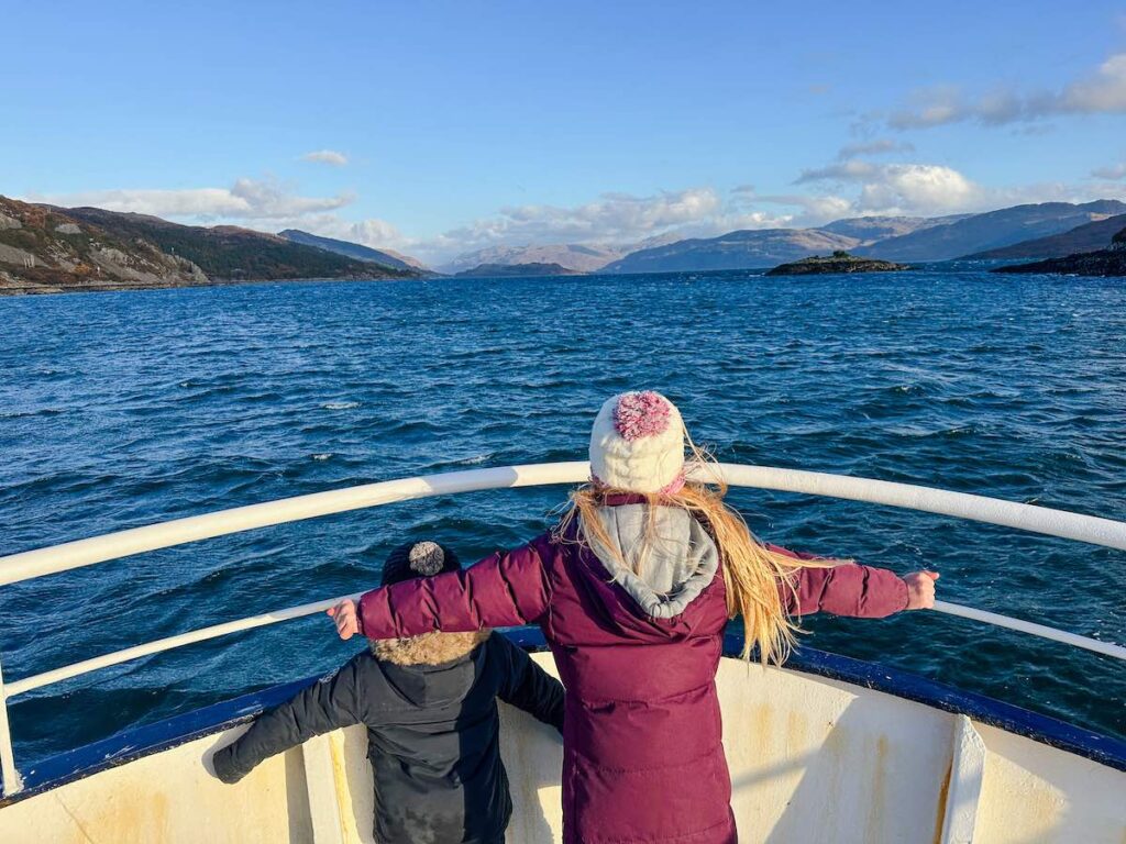 Two kids standing on the deck of the SeaProbe Atlantis glass-bottom boat near the Isle of Skye, enjoying the view