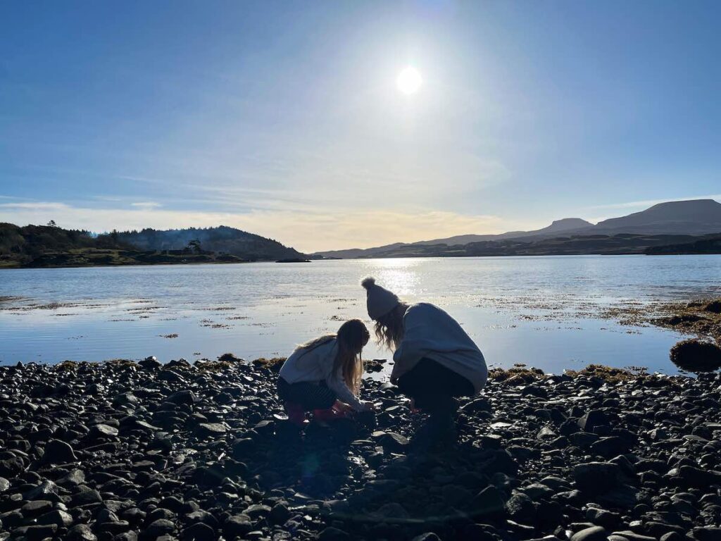 Mum and daughter standing on Scotland’s west coast, enjoying the scenic coastline and rugged landscape